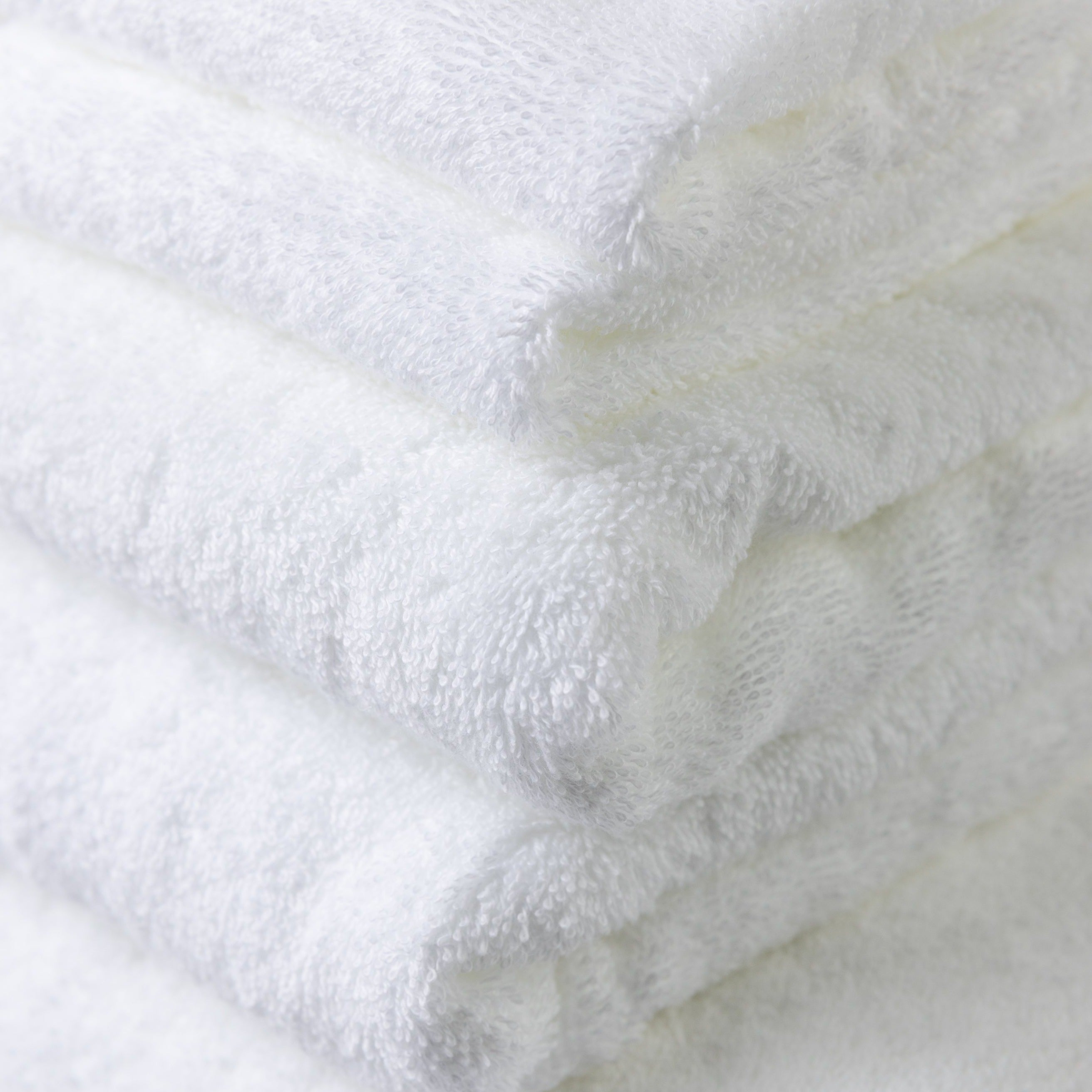 Close photo of the seven piece white 100% cotton bath towel set showing how exceptional and detailed the quality is.
