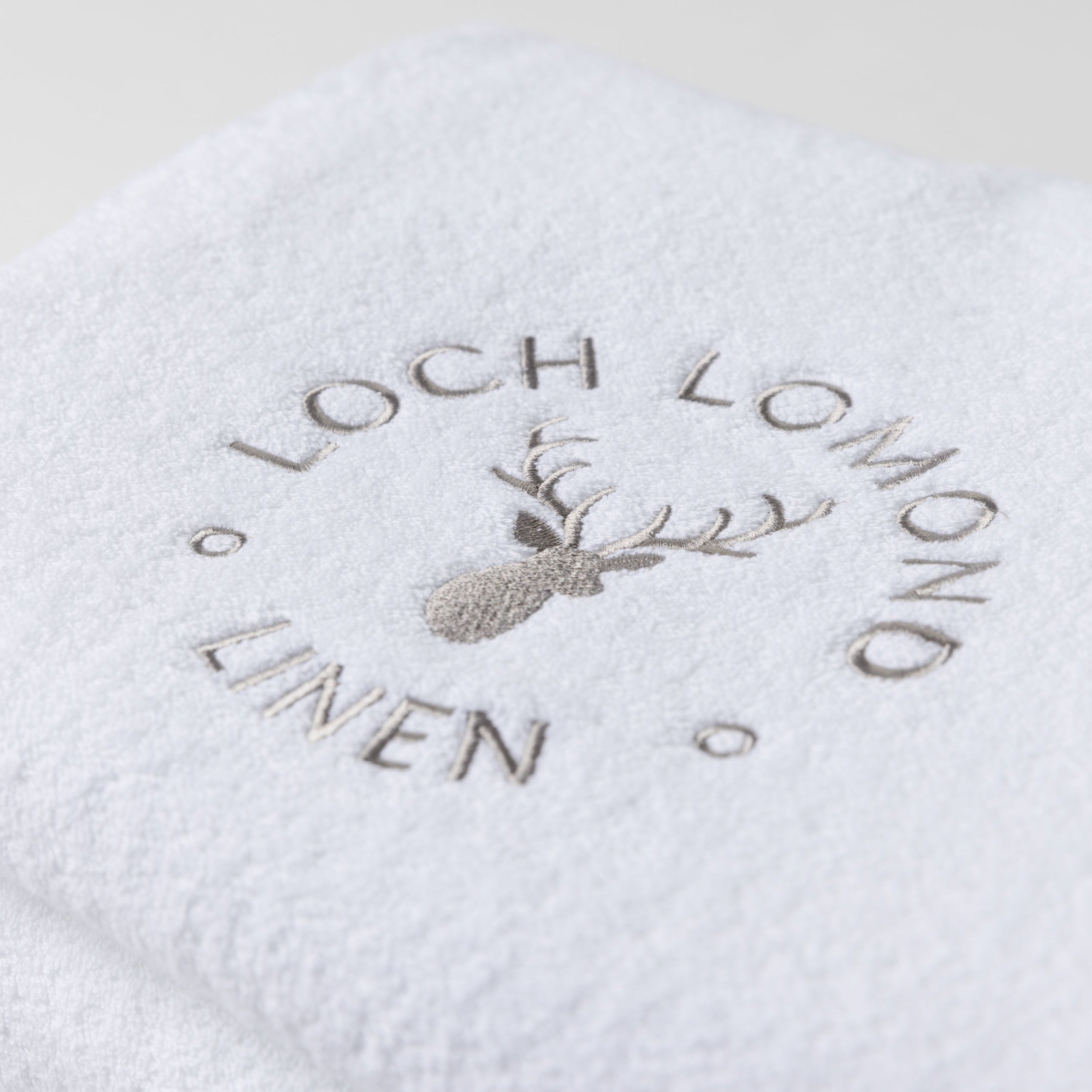 Close photo of the Loch Lomond Linen logo that is embroidered onto the white cotton towels.
