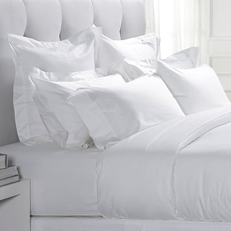 Loch Lomond Linen's luxury white pure cotton sateen bedding set is shown on a bed from the side