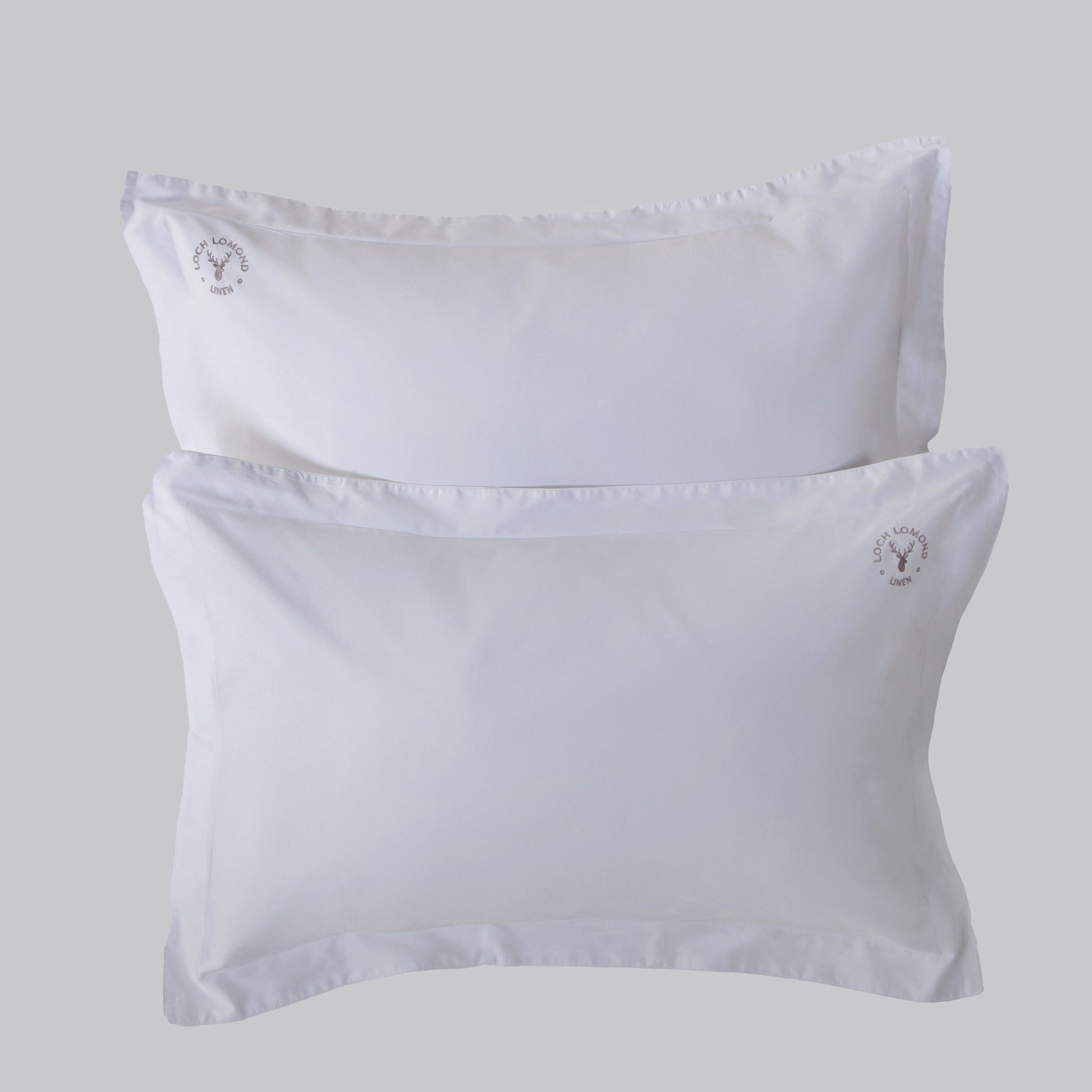 A pair of luxurious Oxford pillowcases are shown with Loch Lomond Linen's logo embroidered in the corners. Made of 100% cotton sateen to ensure the best night's sleep. Available in Standard and Super King sizes.