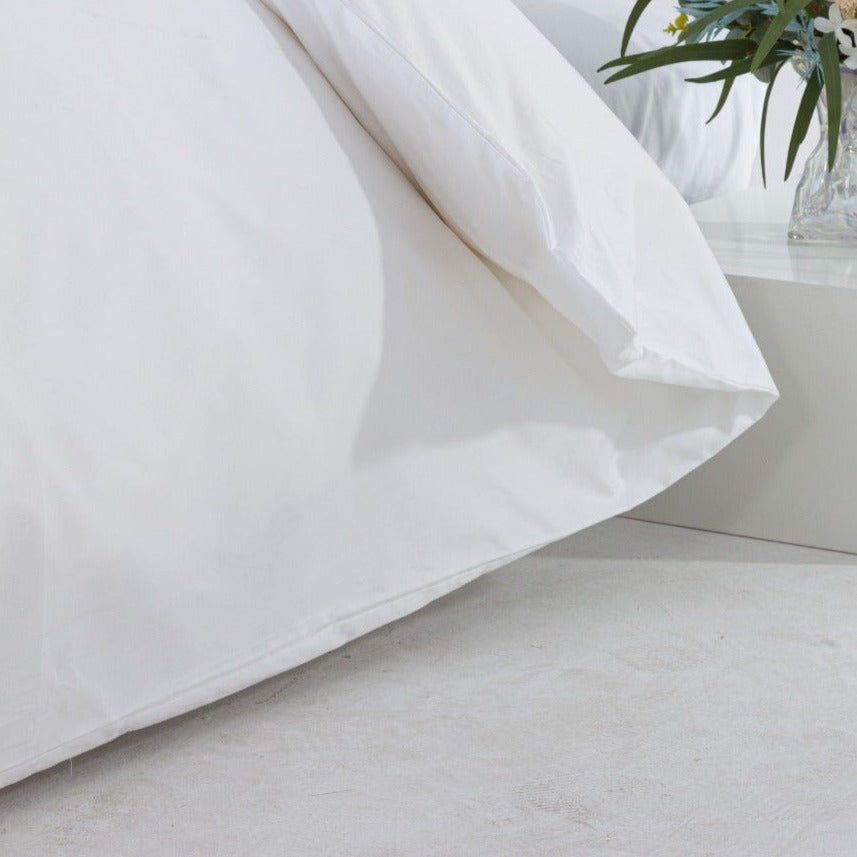 A white duvet cover from Loch Lomond Linen is photographed form the side. The duvet cover is made from the finest 100% 400 thread count cotton sateen for utmost softness and durability. Available in single, double, king, super king and emperor sizes.