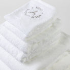 Two bath towels, two hand towels and two face towels are folded into a tower and photographed from the top. The grey Loch Lomond Linen logo is elegantly embroidered on the products.