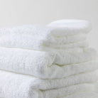 A neatly folded tower of luxurious white Loch Lomond Linen towels.
