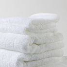 A neatly folded tower of luxurious white Loch Lomond Linen towels.