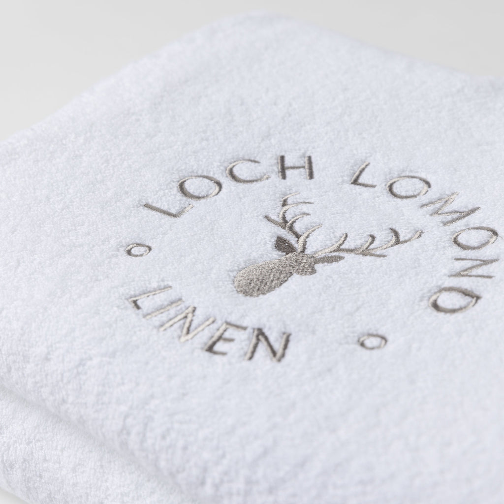 Close photo of the Loch Lomond Linen logo that is embroidered onto the white cotton towels.