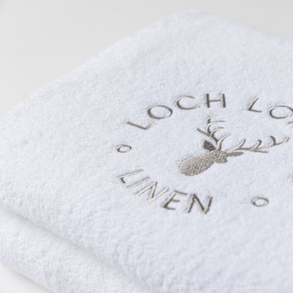 Close photo of the Loch Lomond Linen logo that is embroidered onto the white cotton towels.