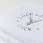 Close photo of the Loch Lomond Linen logo that is embroidered onto the white cotton towels.