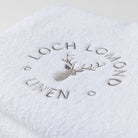 Close photo of the Loch Lomond Linen logo that is embroidered onto the white cotton towels.