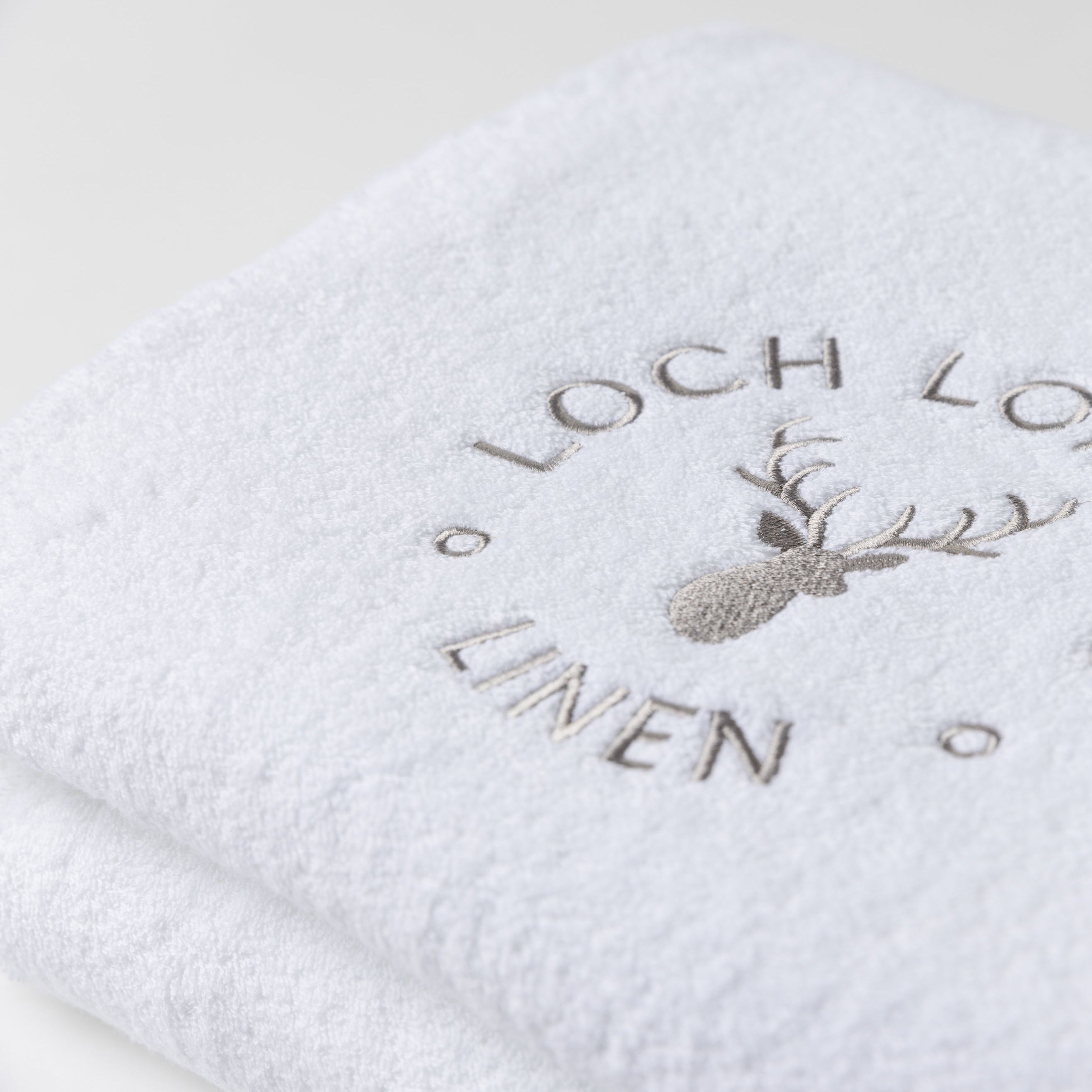 Close photo of the Loch Lomond Linen logo that is embroidered onto the white cotton towels.