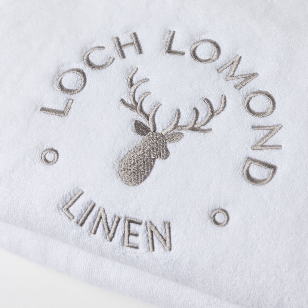 A close photo of the Loch Lomond Linen logo embroidered on the brand's luxurious, extra soft bath sheet.