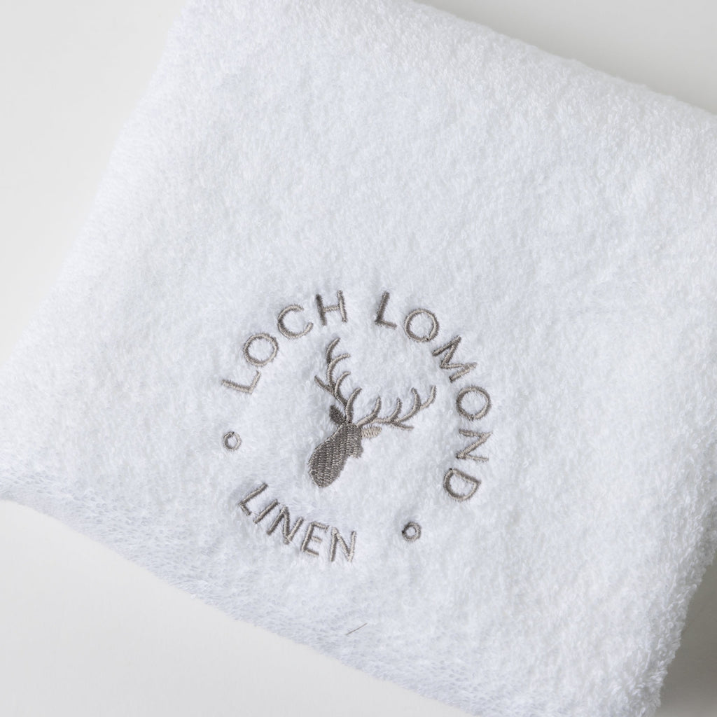 A close photo of the Loch Lomond Linen logo embroidered on the brand's luxurious, extra soft hand towel.