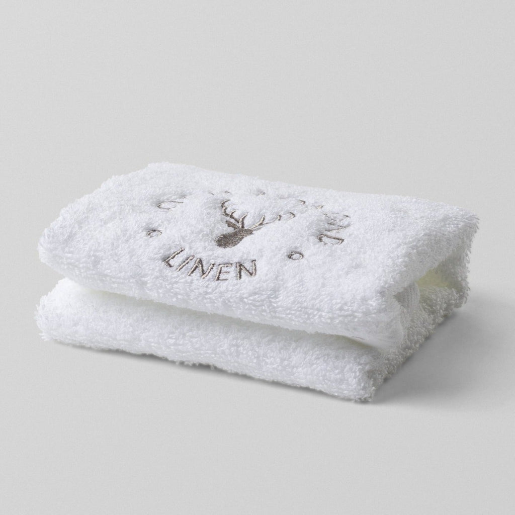 Loch Lomond Linen's white 100% cotton luxury face towel is photographed on it own. The face towel is neatly folded with the elegant grey logo showing on the top.